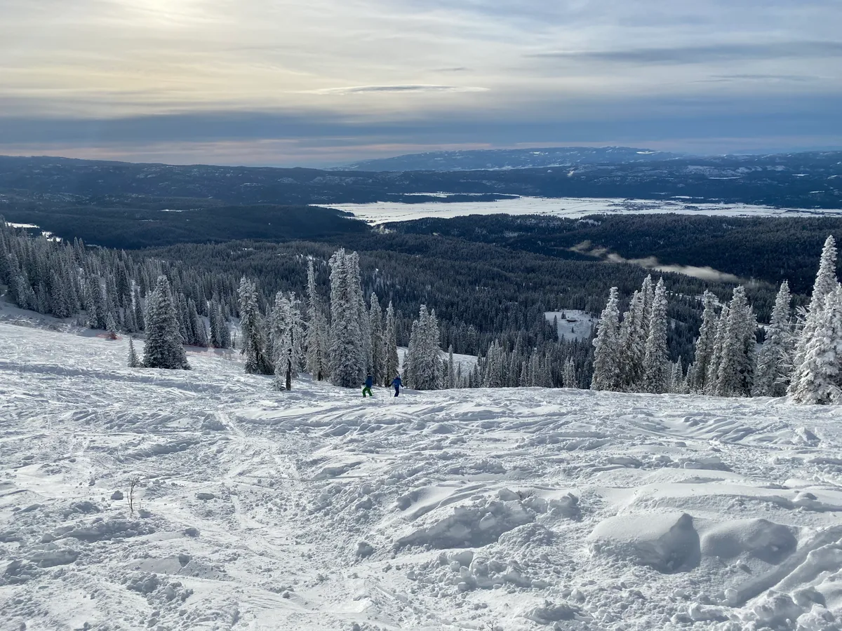 View from the mountain over trees to a frozen lake and the valley