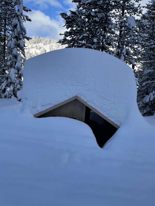 A building almost buried under deep snow