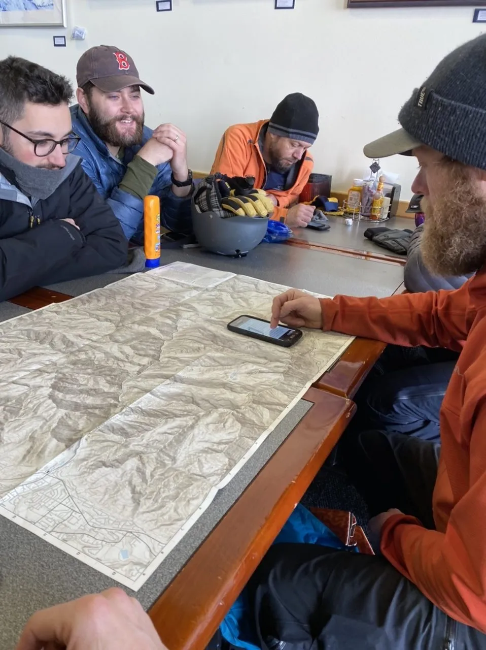 Group studying a topographic map and phone at a table before the tour